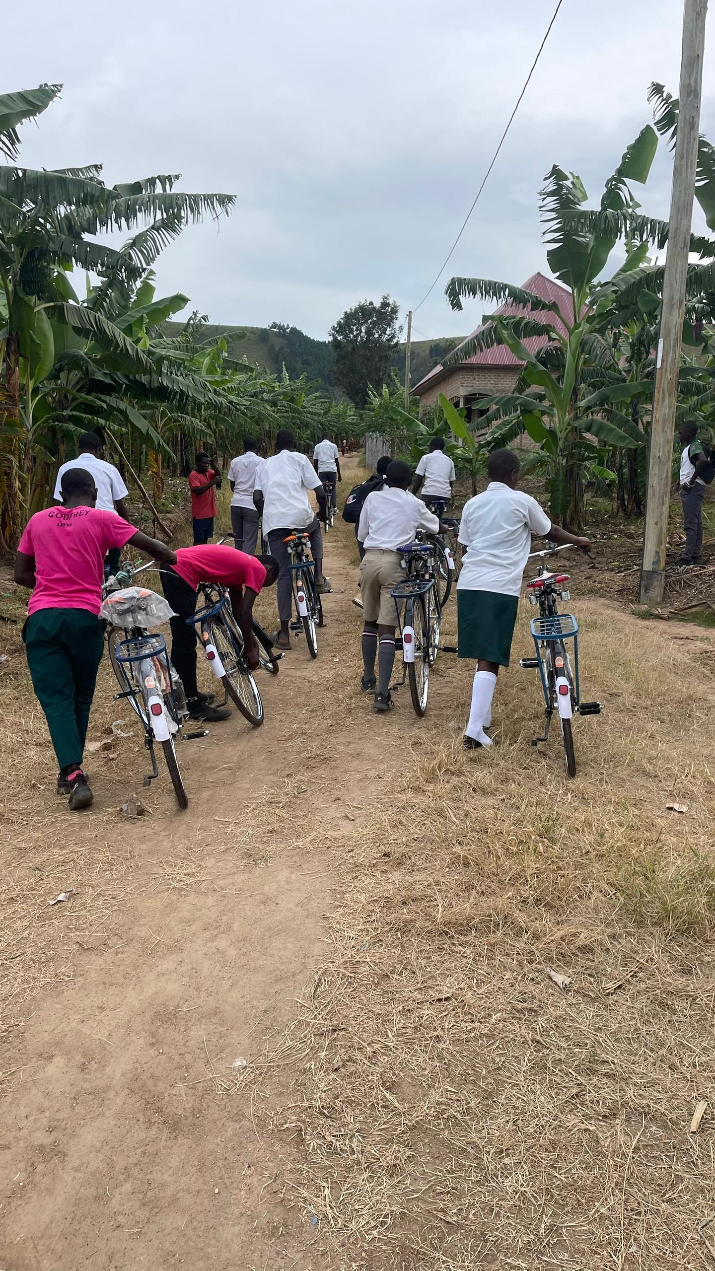 Students riding bicycles along a rural road